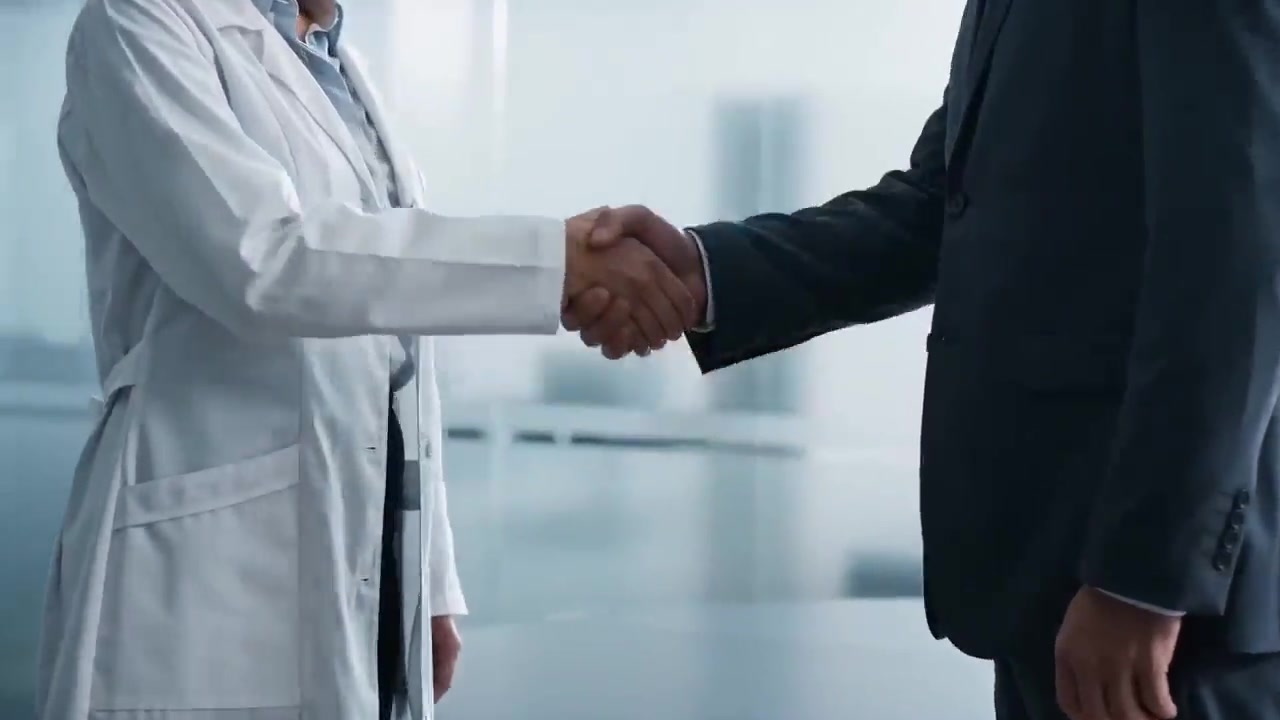 A clinician and an executive shaking hands